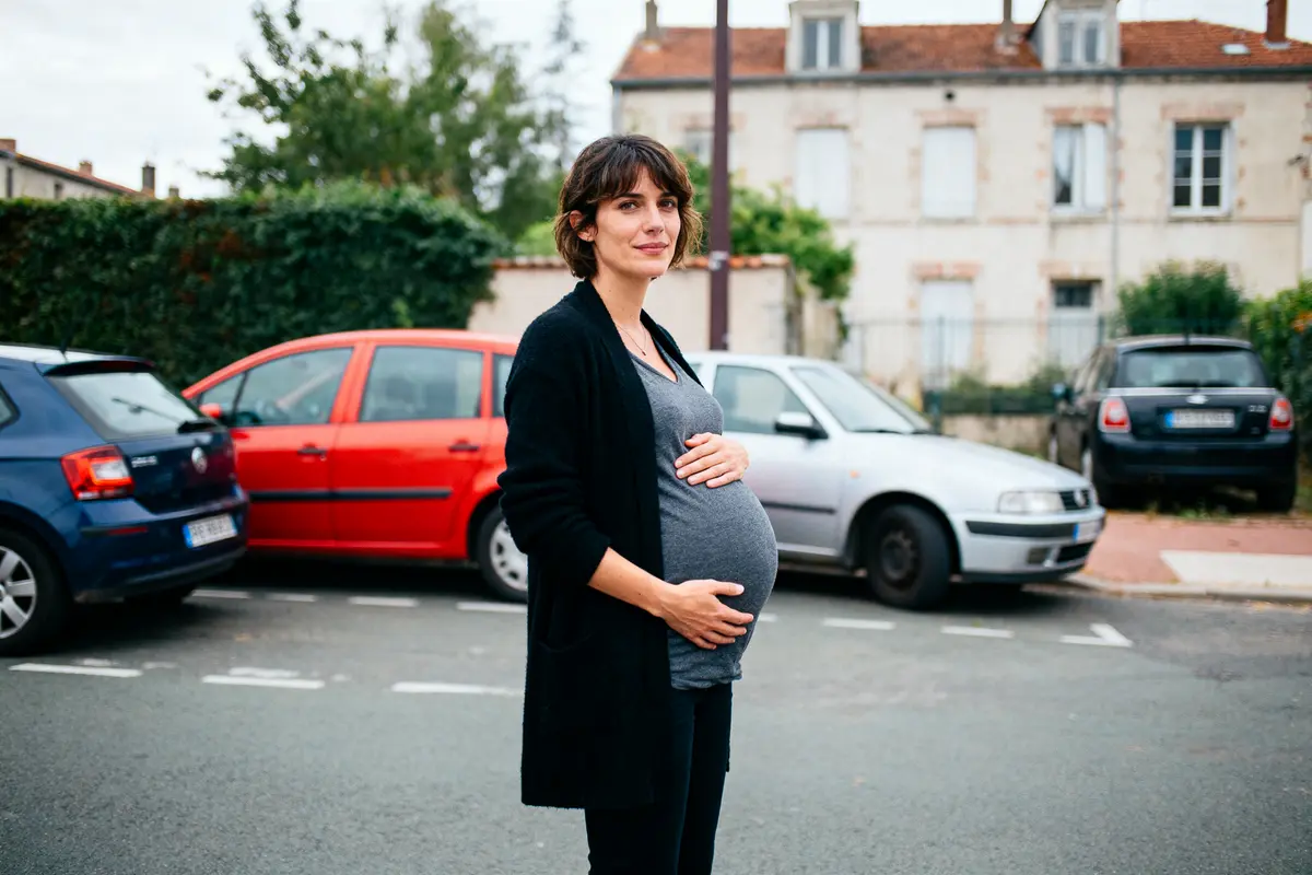 pexels-michal-pech-213601-757318 (1) Une femme enceinte se tient debout dans une rue, entourée de voitures.
