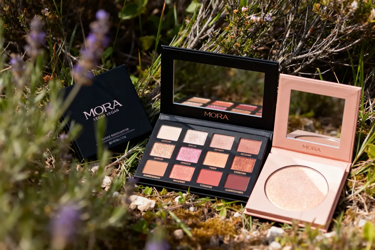 pexels-michal-pech-213601-757318 (1) Maquillage Mora vegan, palette de fards à paupières et poudre, posée dans la nature.