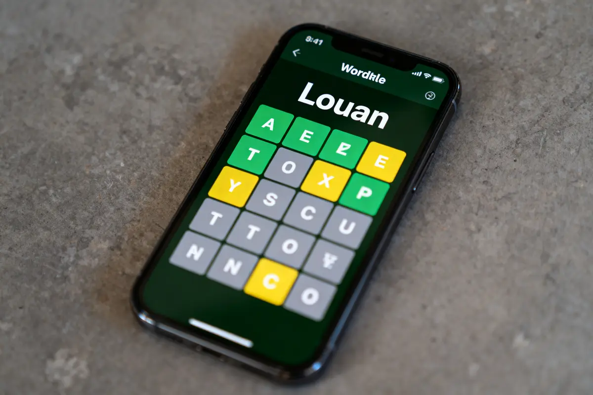 pexels-michal-pech-213601-757318 (1) Smartphone affichant un jeu de mots "Wordle" avec des lettres colorées en jaune, vert et gris.