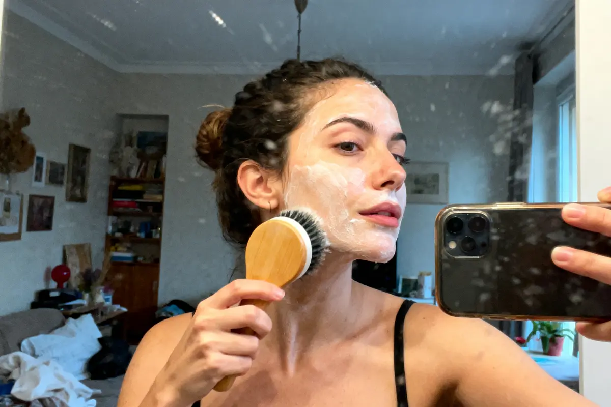 pexels-michal-pech-213601-757318 (1) Femme appliquant un masque facial avec une brosse, prenant un selfie devant le miroir.