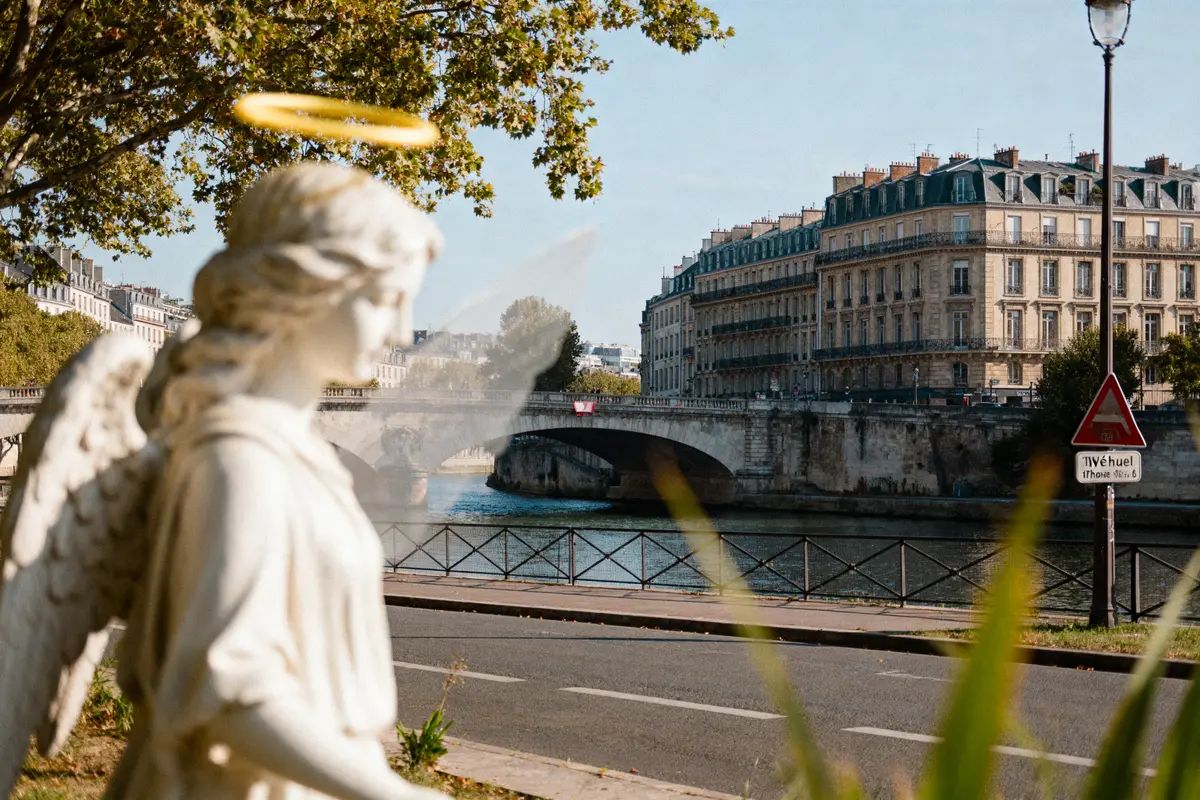 pexels-michal-pech-213601-757318 (1) Statue d'ange avec auréole devant un pont parisien et bâtiments historiques en arrière-plan.