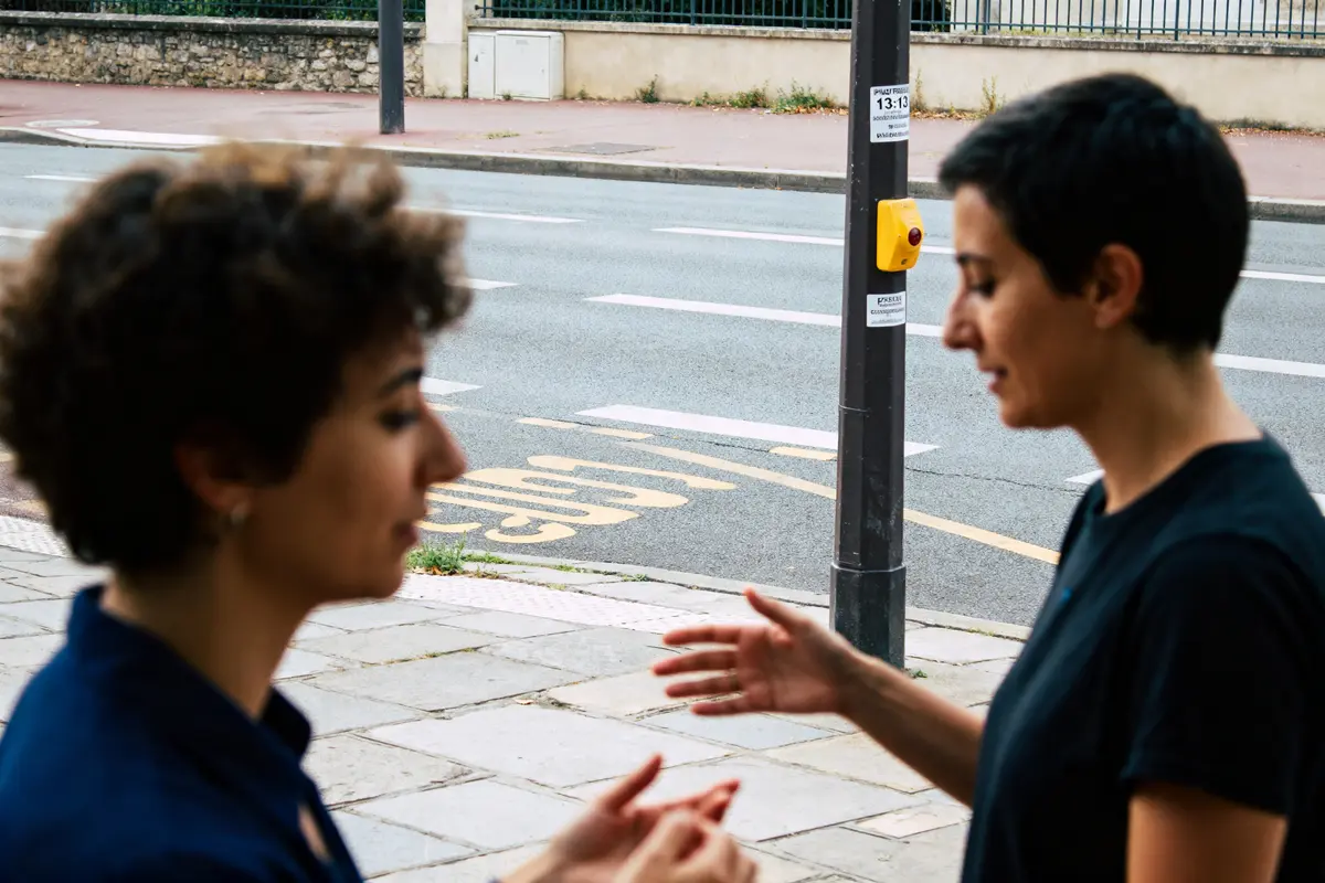Deux personnes discutent près d'un panneau indiquant signification de 13h13 amour en rue.
